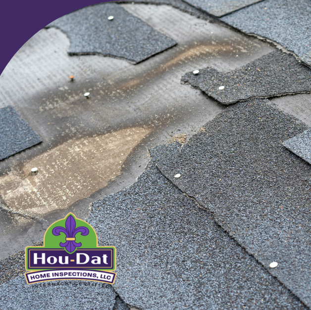 Close-up of damaged shingles on a roof with exposed underlayment and nails.