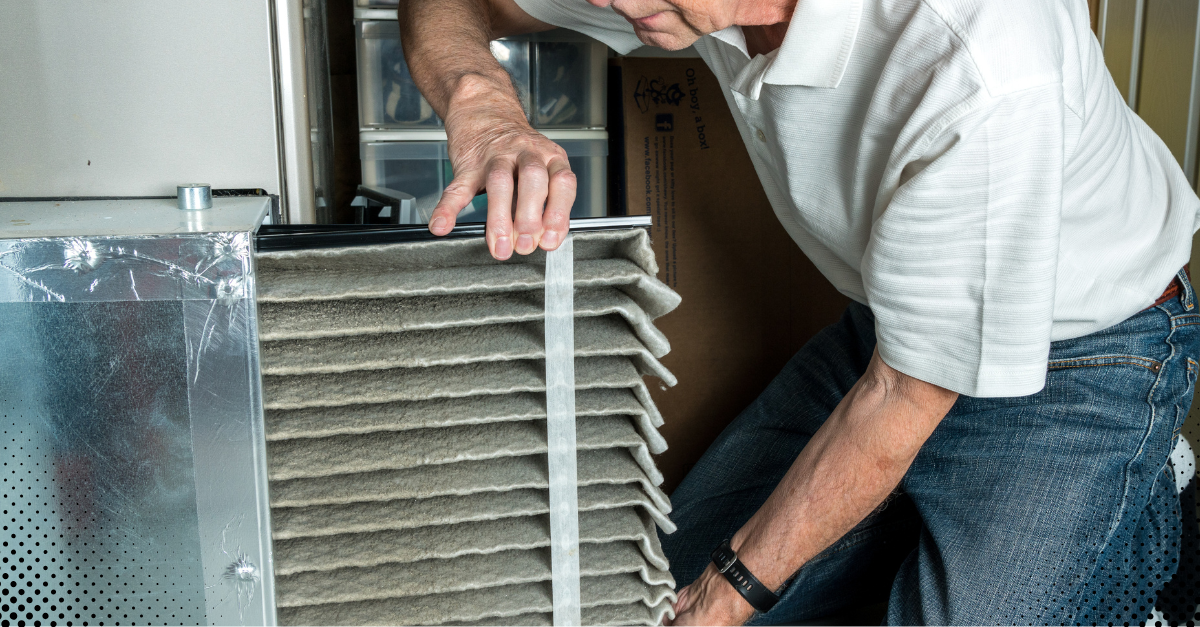 Person changing air filter in an HVAC system.